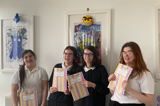 The group posing with their booklets
