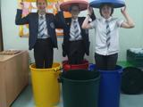 The group standing in recycling bins