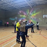 Roller disco in full swing with young people skating around the hall 