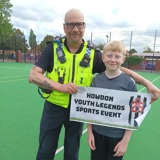 Police officer and young person with event sign